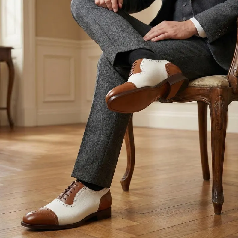 White and brown wingtip Oxford shoes with brogue detailing