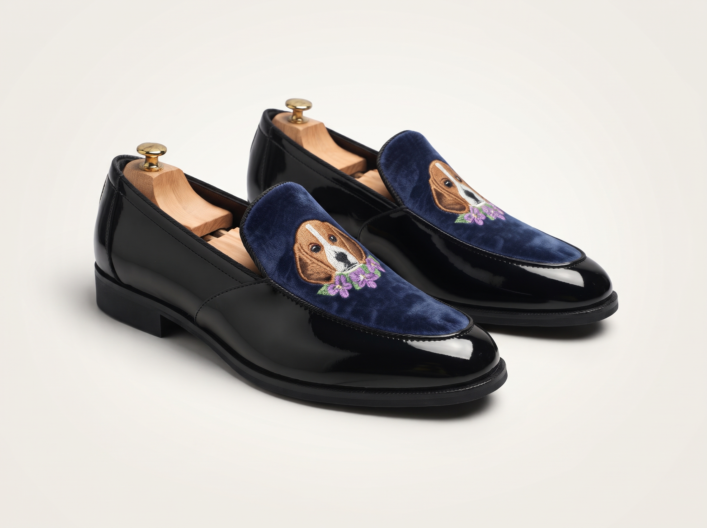 Black patent leather loafers with navy blue velvet panels and embroidered animal designs